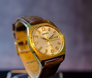 A gold watch with a leather band Description automatically generated