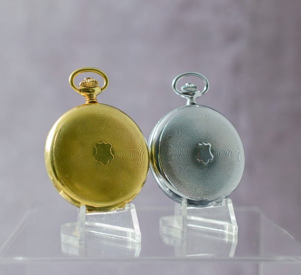 A pair of gold and silver pocket watches Description automatically generated with low confidence