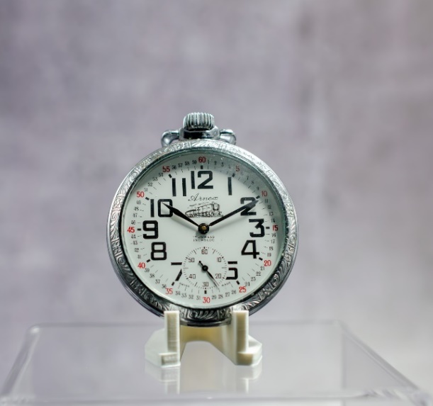 A picture containing clock, analog watch, watch, silver Description automatically generated