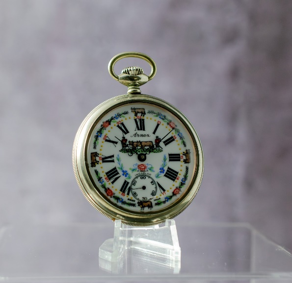 A pocket watch on a stand Description automatically generated with low confidence