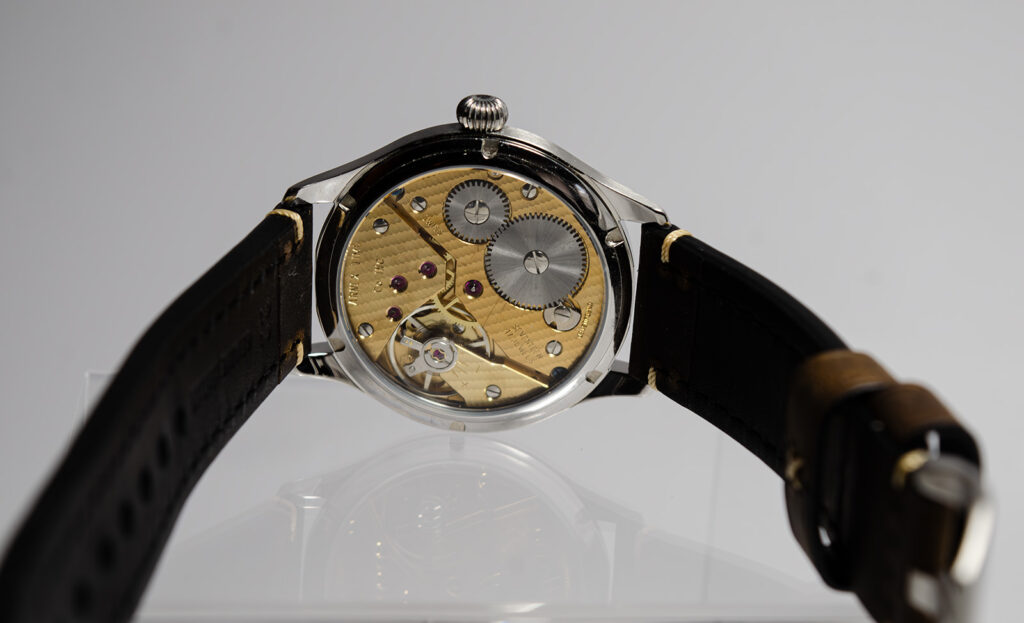 Close-up of Beobachtungsuhr watch movement with gold-toned bridges, visible jewels, and historic serial engravings