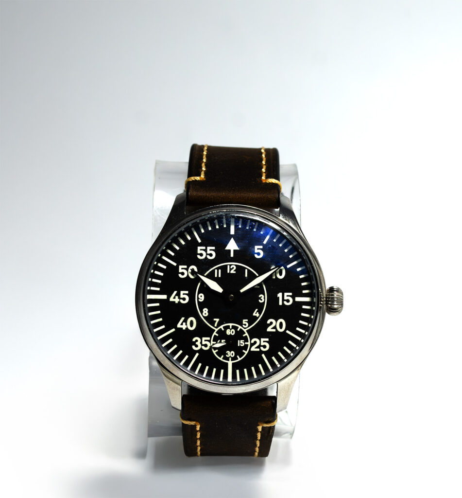 A direct look at a vintage B-Uhr pilot's watch—highlighting its high-contrast dial, stitched leather strap, and iconic aviation layout.